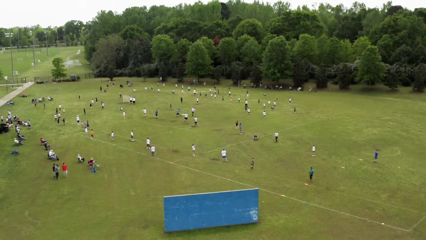 People are playing sports on large field on overcast day