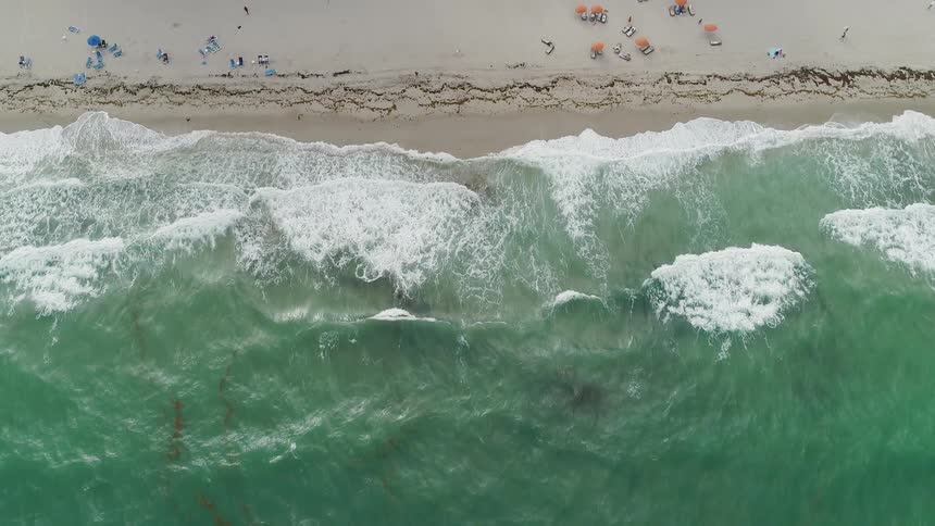 Ocean waves flow towards a sandy beach