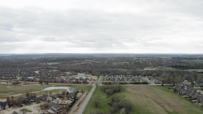 Cars drive in a town on a cloudy day