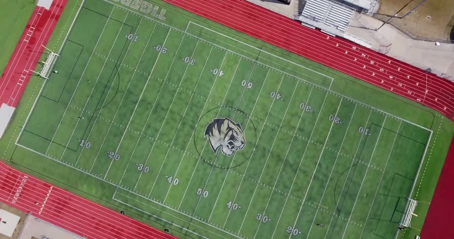 A person runs on a football field