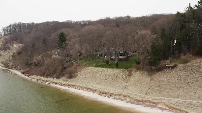 A rural house sits on a shoreline