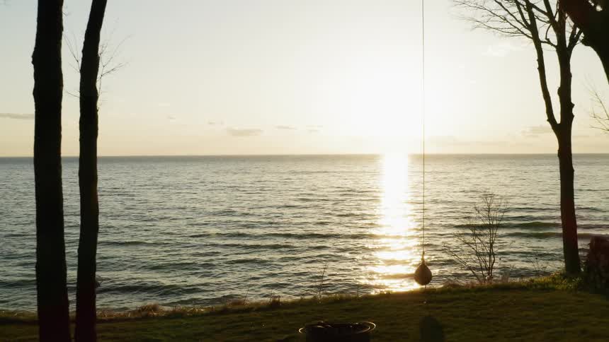 The sun is casting a beam of light on the ocean at sunset