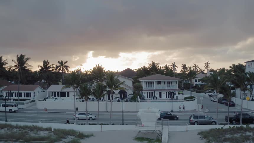 The cars drive on the road in the beach town