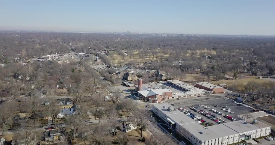A two lane road separates homes in a neighborhood from business buildings