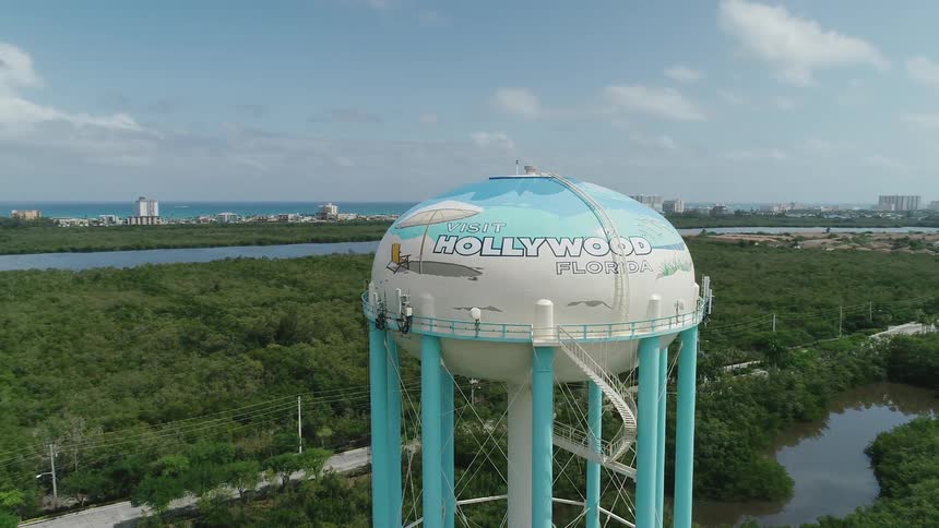 A large water tower towers above the trees