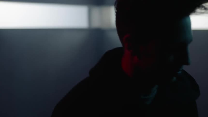 A man bangs his head in a dark room