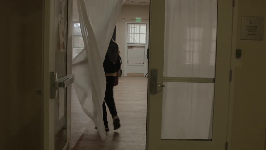 A man walks through a curtained doorway into a dance studio