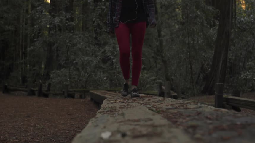 A woman walks through the woods