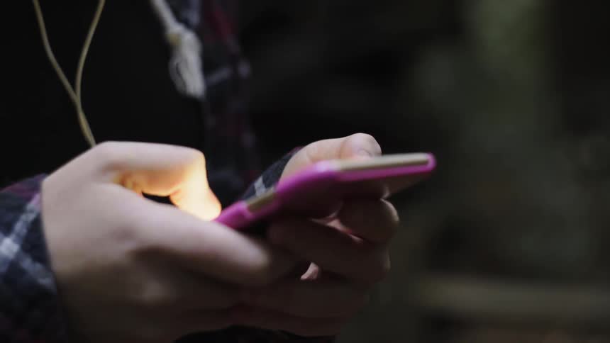 Fingers scroll and type on a smartphone