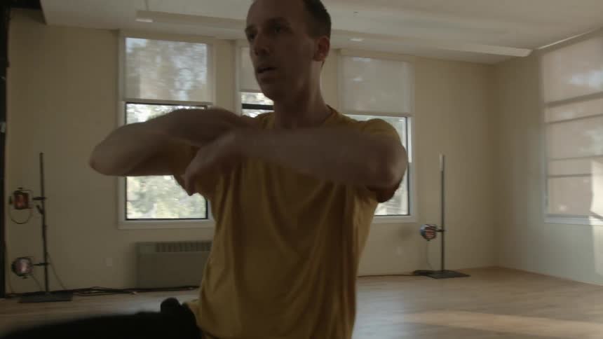 A man dances in an empty room