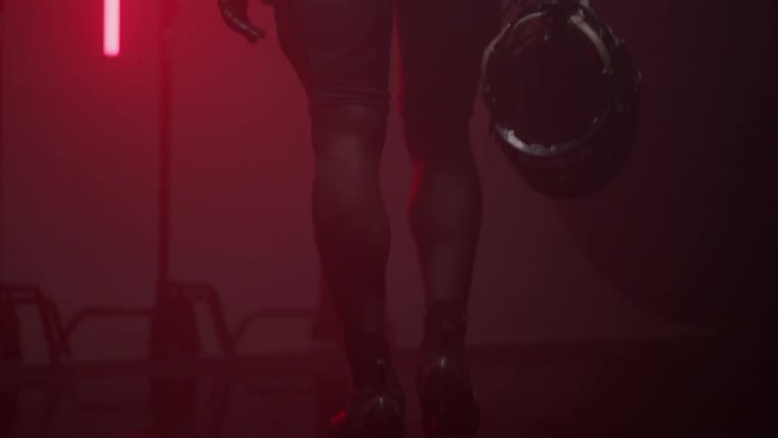 A football player walks in a room with red lights