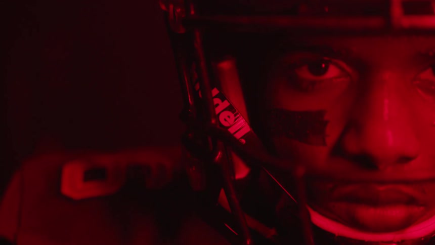 Man in a football helmet stands under the flashing light