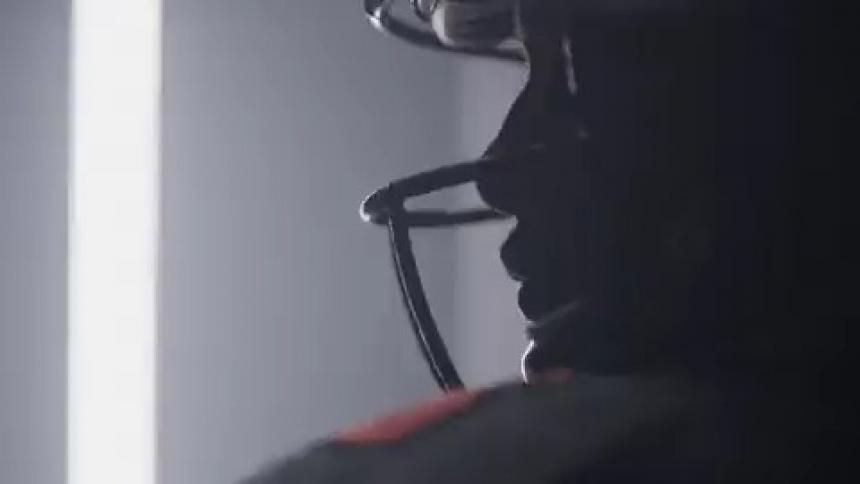 Person stands still wearing a football helmet