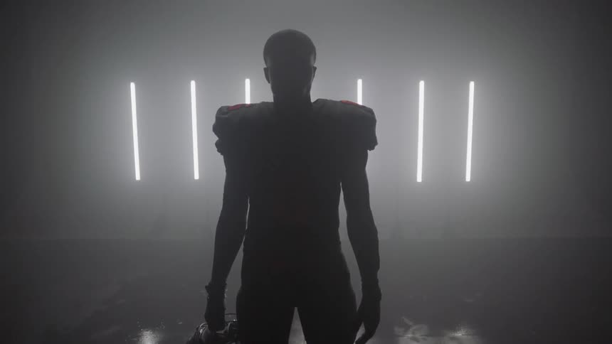 A football player stands in a row with white strip lights