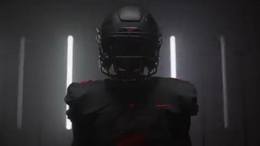 A football player stands in a room with flashing lights