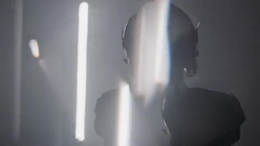 Flashing lights surround a football player in a room who is looking upwards
