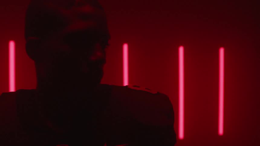 Football player is standing in room with red lights