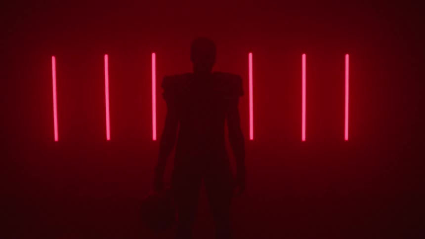 A football player stands in front of glowing red lights