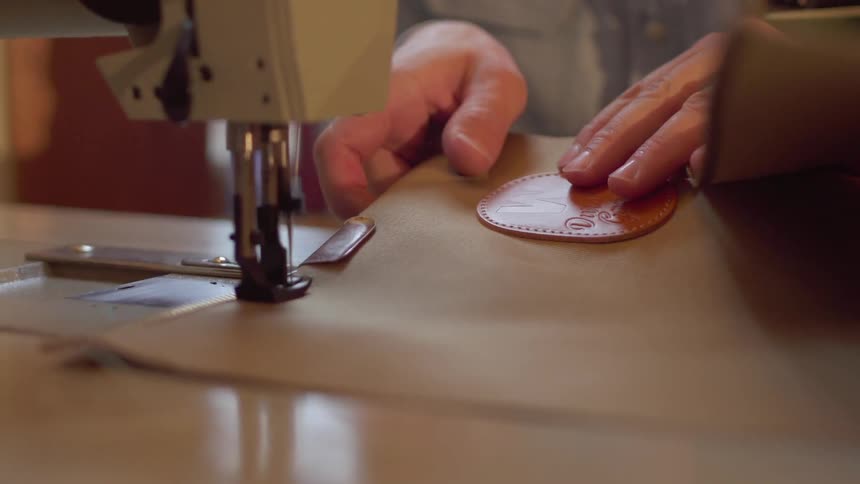 A person sews thick fabric using a sewing machine