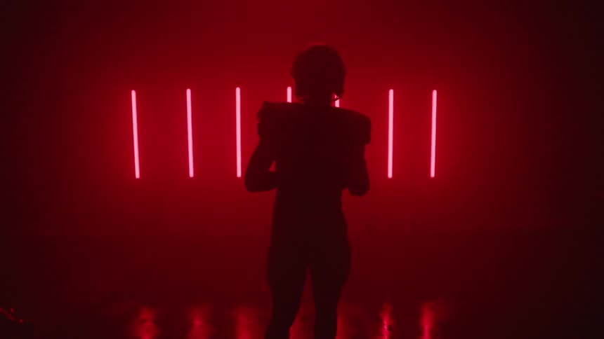 A football player stands in a room with red lights