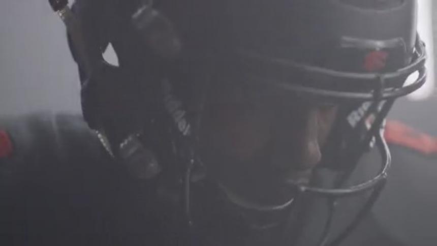 Man wearing hockey gear stands under a flashing light