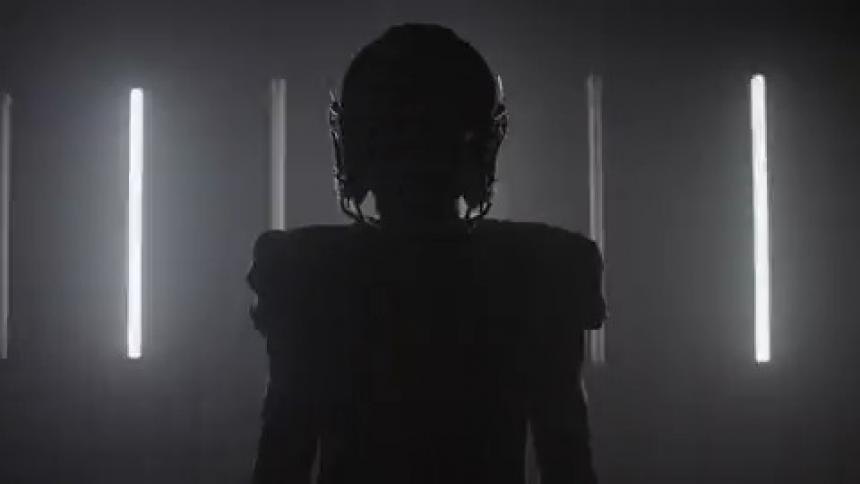 A football player stands in a room with flashing lights