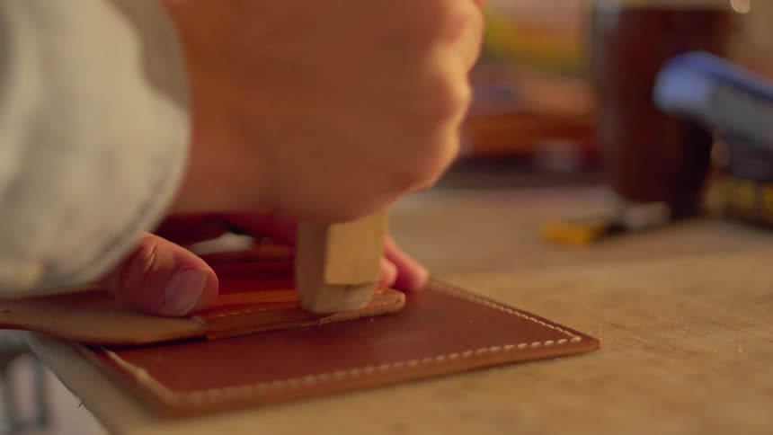 A man fabricates with wood and leather