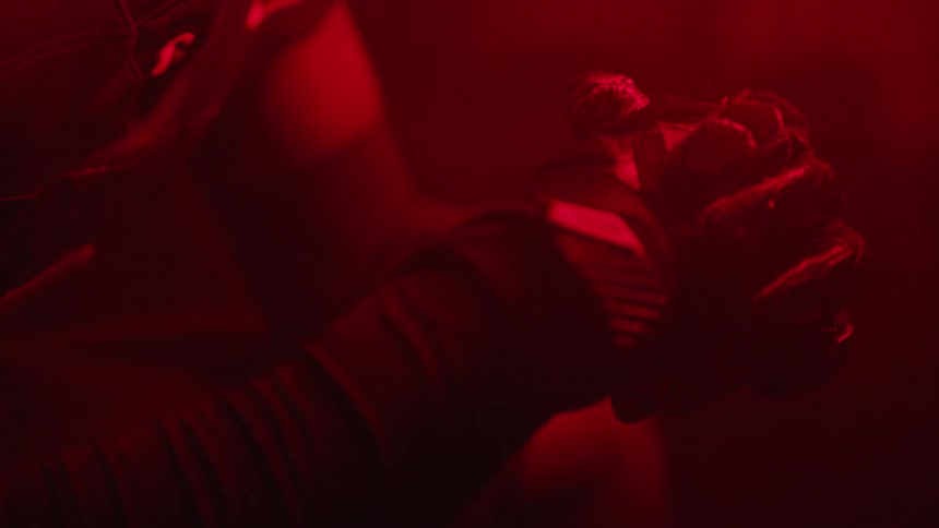 The player raises his hand in the dark room