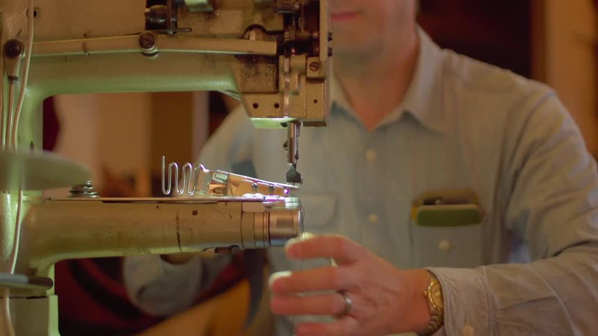 The man is operating a sewing machine