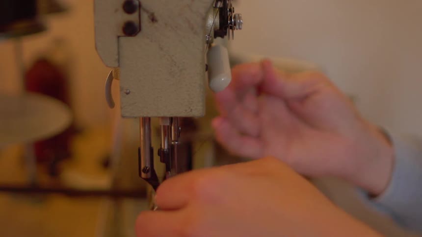 The person works feeding thread through the machine