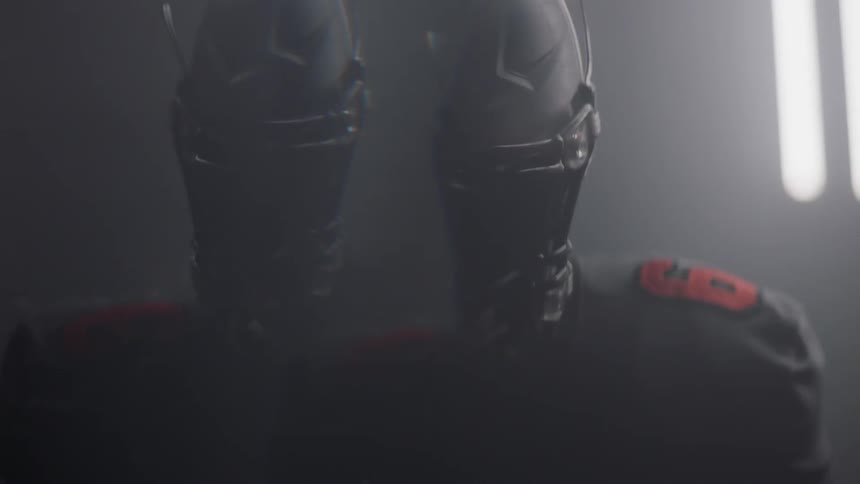 A football player stands by flashing lights