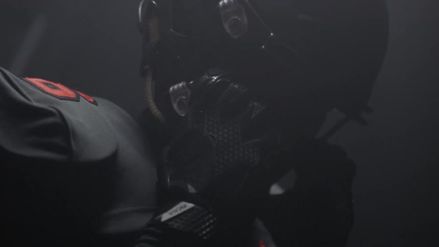 The man tightens his football helmet