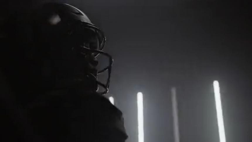 A football player stands by flashing lights