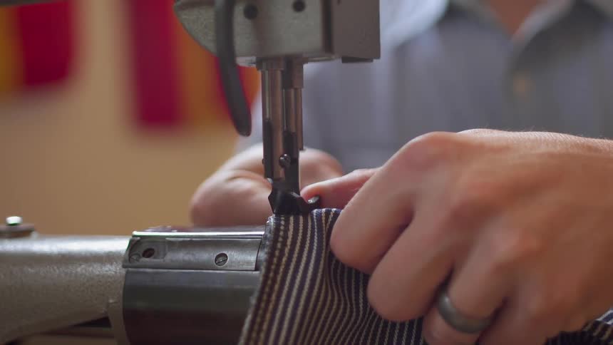 A man uses a stitching machine