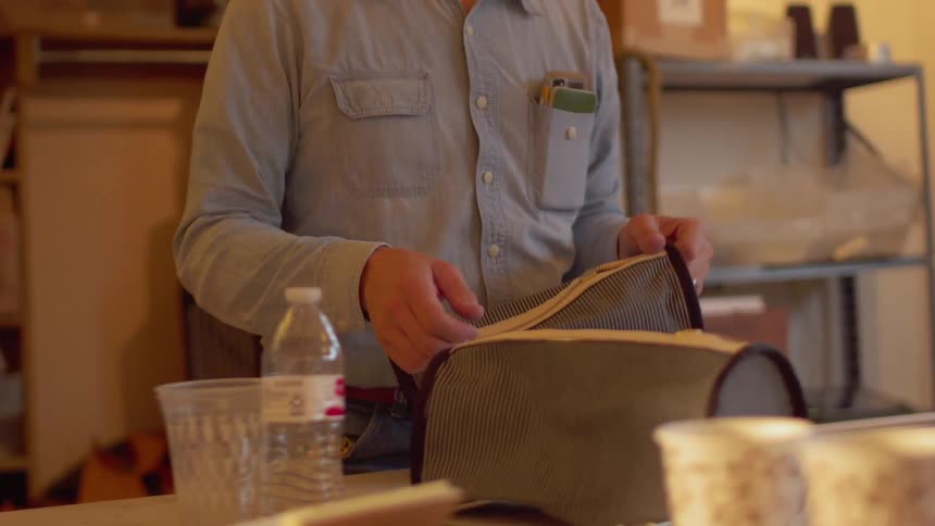 A man sews bags in a workshop