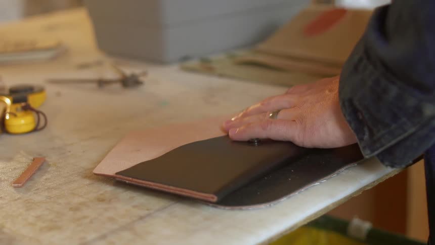 Man is making leather coin purse