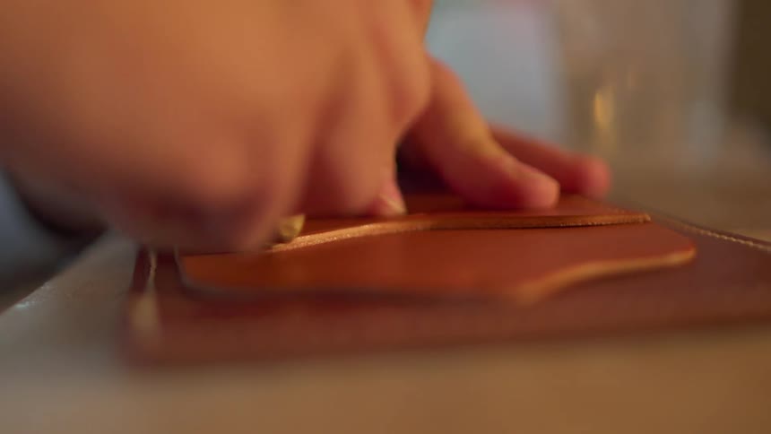 The person is working gluing leather