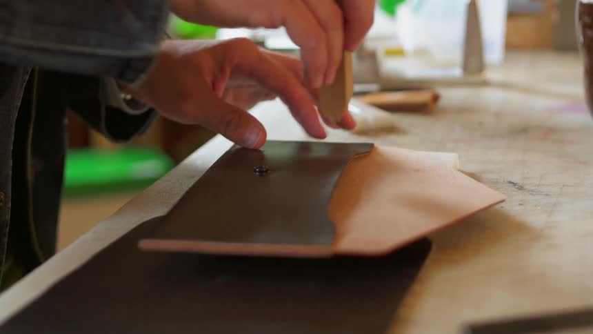 The man is tracing a small pouch