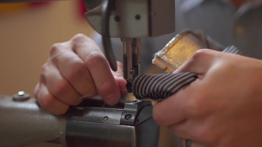 A person puts cloth into a sewing machine