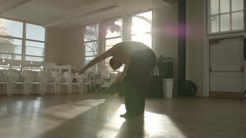 A man dances in a studio alone during the day