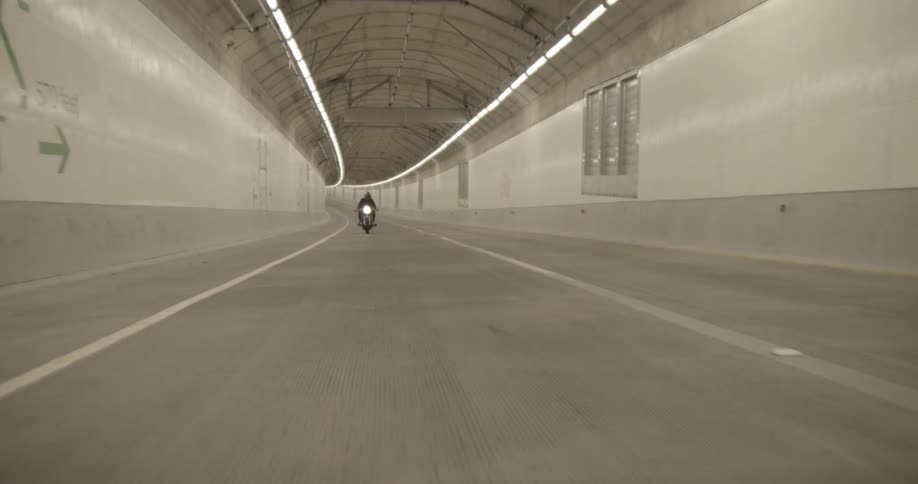 The motorcycle travels through the tunnel