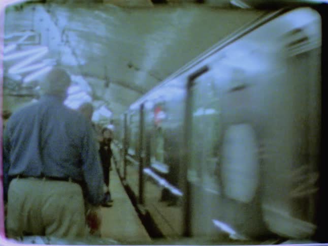 People standing on a train platform as a train speeds by