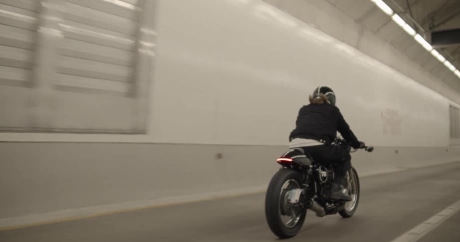 The motorcycle passes the tiles of the tunnel