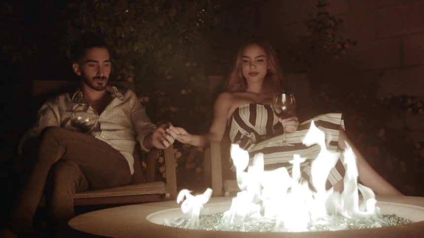People hold hands by a fire pit