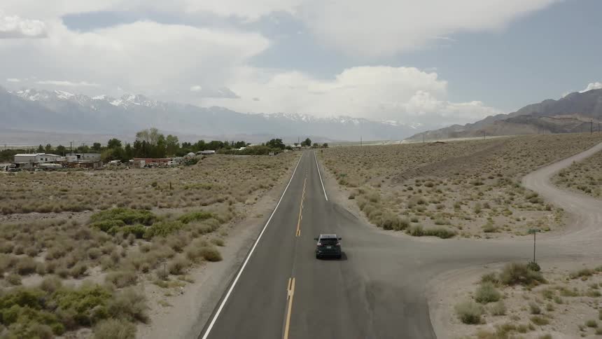 A black car drives on the road