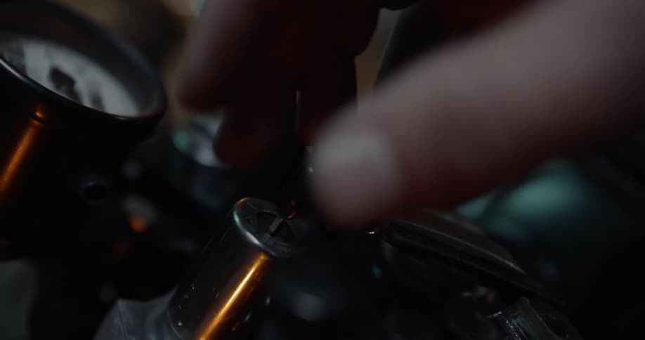 A hand touches a key in an ignition