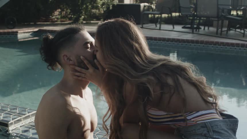 A man and woman kiss in the pool