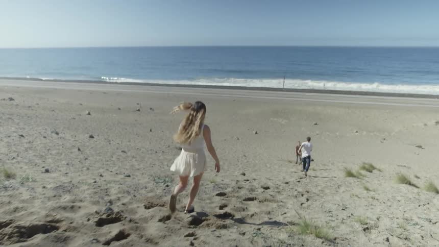 Woman runs on the beach towards the water