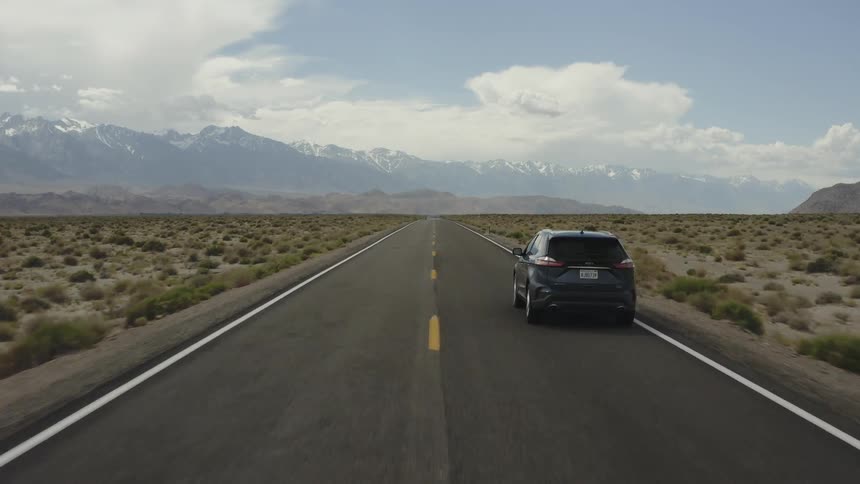 A car is driven on a rural desert road