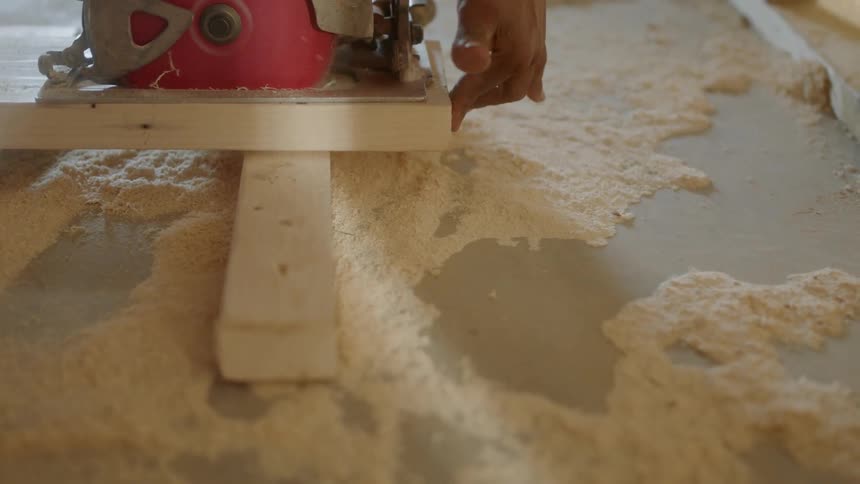 The person uses the saw to cut wood